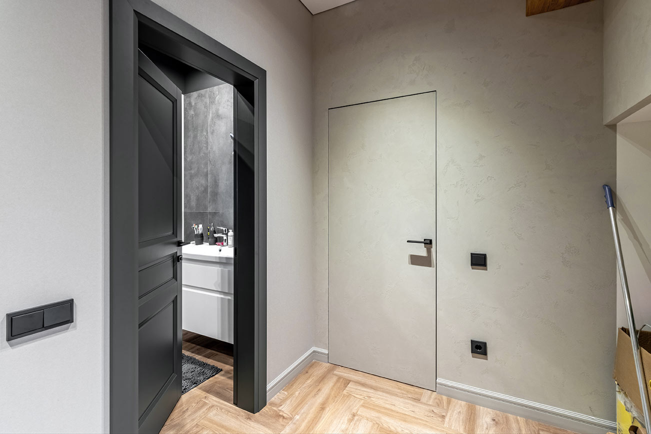 Rahmenlose Innentür in grauer Wand mit minimalistischer Optik