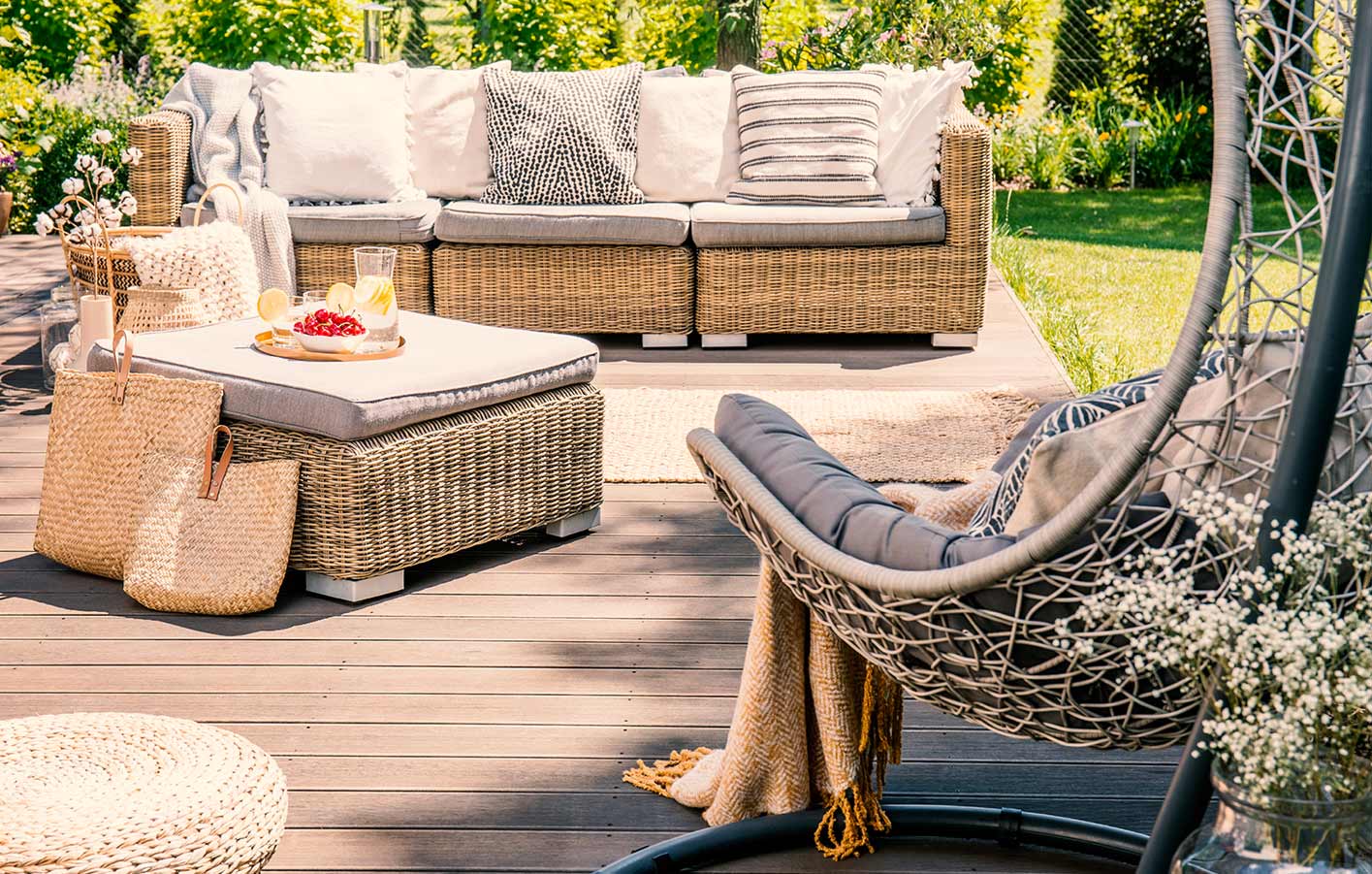 Gemütliche Gartenlounge auf Holzterrasse mit Sitzmöbeln und Dekoration